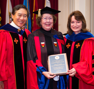 Catherine Fenselau (center) receiving her award from UMD President Wallace D. Loh (left) and UMD Senior Vice President and Provost Mary Ann Rankin (right) at the 2017 Faculty and Staff Convocation. Photo: Lisa Helfert (Click image to download hi-res version.)