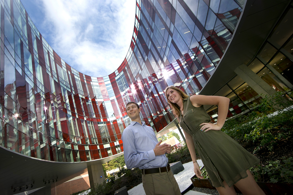 Physics students Ben Reschovsky and Katie Hergenreder stand under the ellipse of the Physical Sciences Complex at UMD. Photo: John T. Consoli