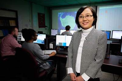Eun-Suk Seo, UMD professor of physics and head of the UMD Cosmic Ray Physics Group, stands in the on-campus control room where her students and technicians help monitor Long Duration Balloon (LDB) missions when they are underway in Antarctica. Behind her are [L-R]: postdoctoral research associate Jacob Smith, lab assistant Oluchi Ofoha, and undergraduate researcher Nathan Anthony. Image Credit: Faye Levine/UMD (Click image to download hi-res version.)