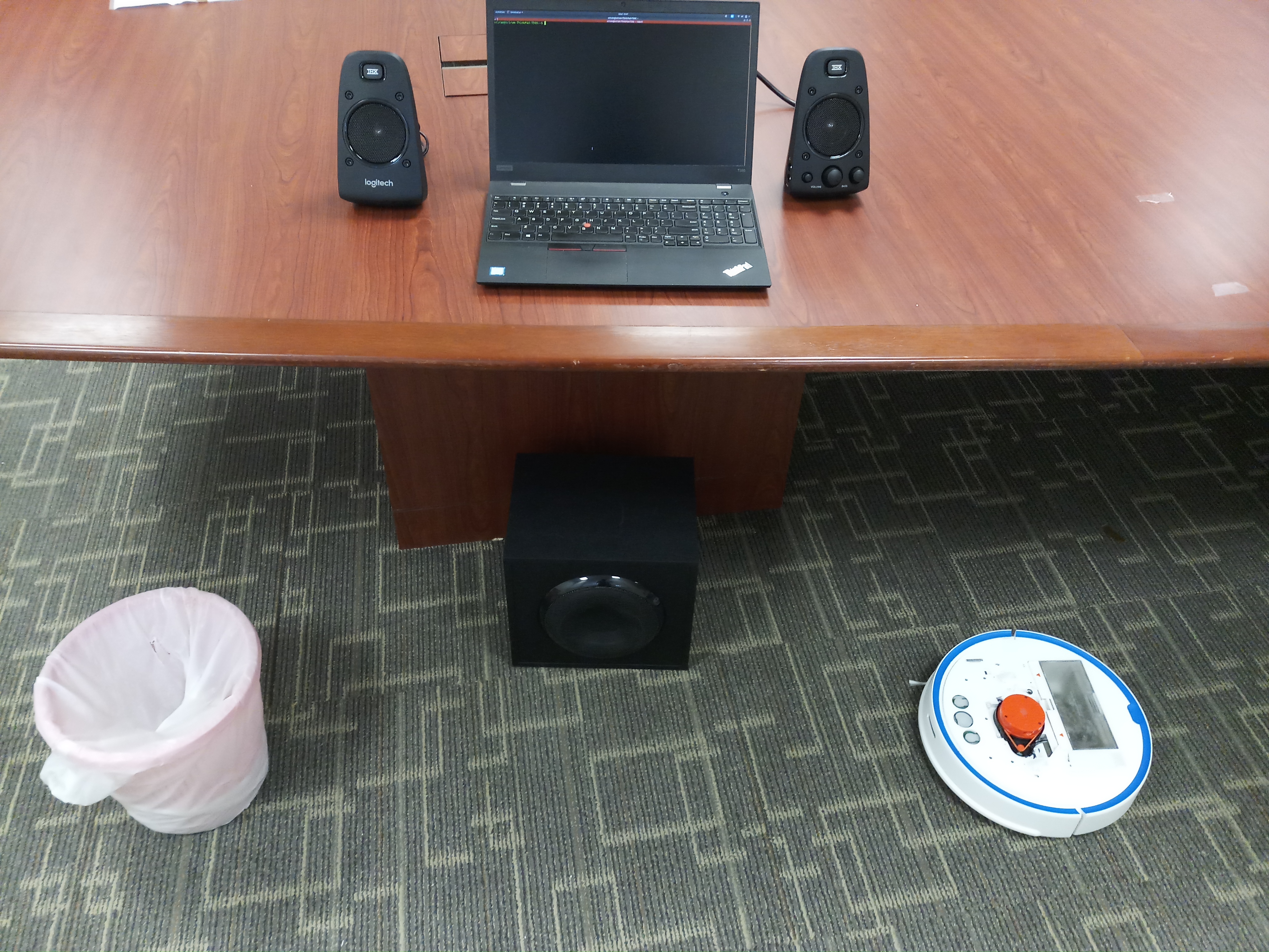 Researchers repurposed the laser-based navigation system on a vacuum robot (right) to pick up sound vibrations and capture human speech bouncing off objects like a trash can placed near a computer speaker on the floor. Photo credit: Sriram Sami