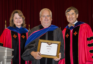 Jeffery Davis (center) receiving his award from UMD President Wallace D. Loh (right) and UMD Senior Vice President and Provost Mary Ann Rankin (left) at the 2018 Faculty and Staff Convocation. Photo: Stephanie S. Cordle, University of Maryland (Click image to download hi-res version.)