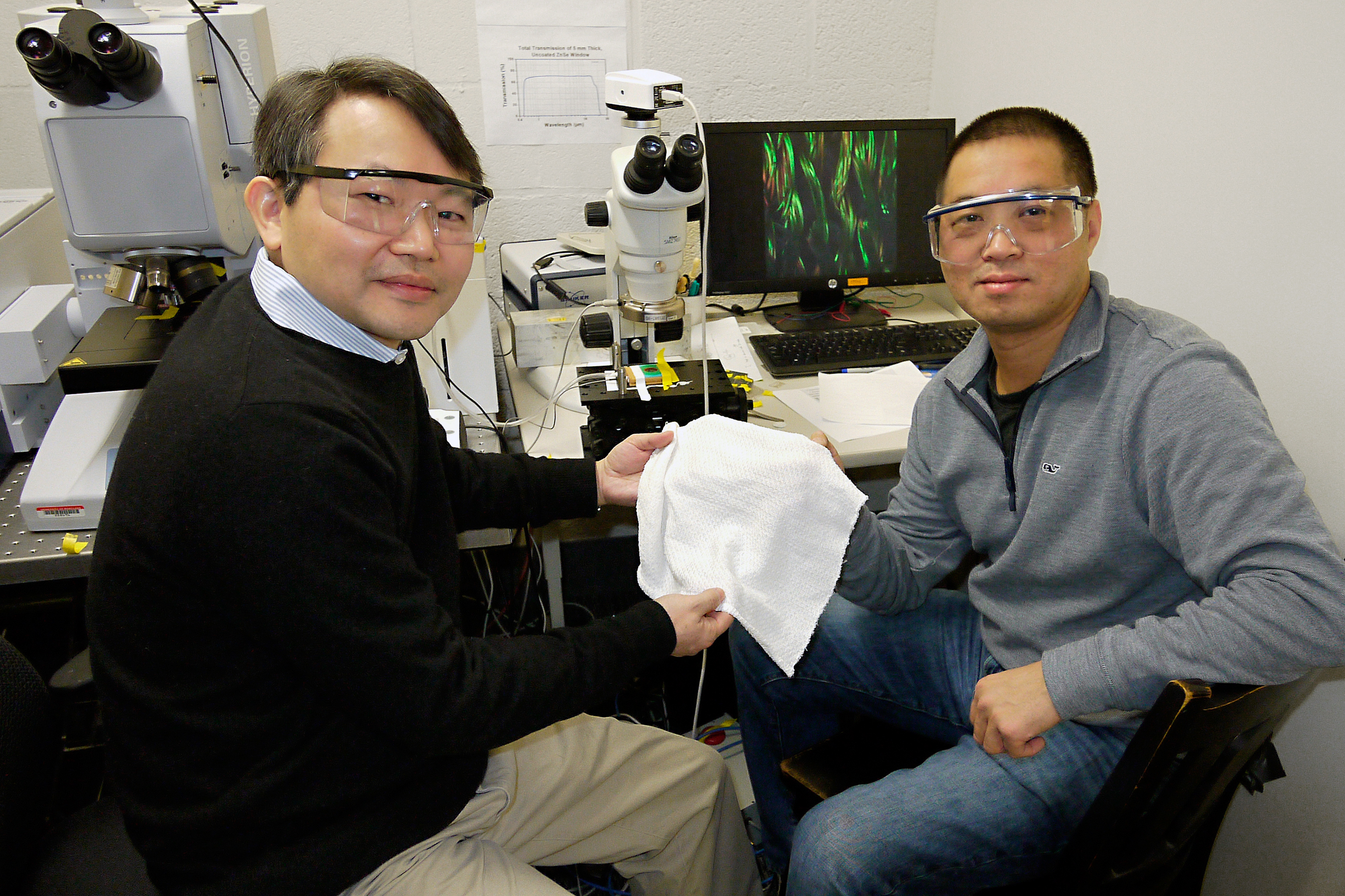 University of Maryland Chemistry and Biochemistry Professor YuHuang Wang (left) and Physics Professor Min Ouyang hold a swatch of their new fabric that can automatically adjust its insulating properties to warm or cool a human body.  Photo: Faye Levine, University of Maryland (Click image to download hi-res version.)