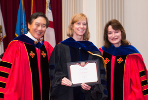 Karen Carleton (center) with University of Maryland President Wallace D. Loh (left) and University of Maryland Senior Vice President and Provost Mary Ann Rankin (right) receiving her award at the 2017 Convocation. Photo: Lisa Helfert (Click image to download hi-res version.)