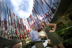 Physics graduate student Ben Reschovsky and undergraduate student Katie Hergenreder stand under the ellipse of the new Physical Sciences Complex. Photo: John Consoli (Click image to download hi-res version.)